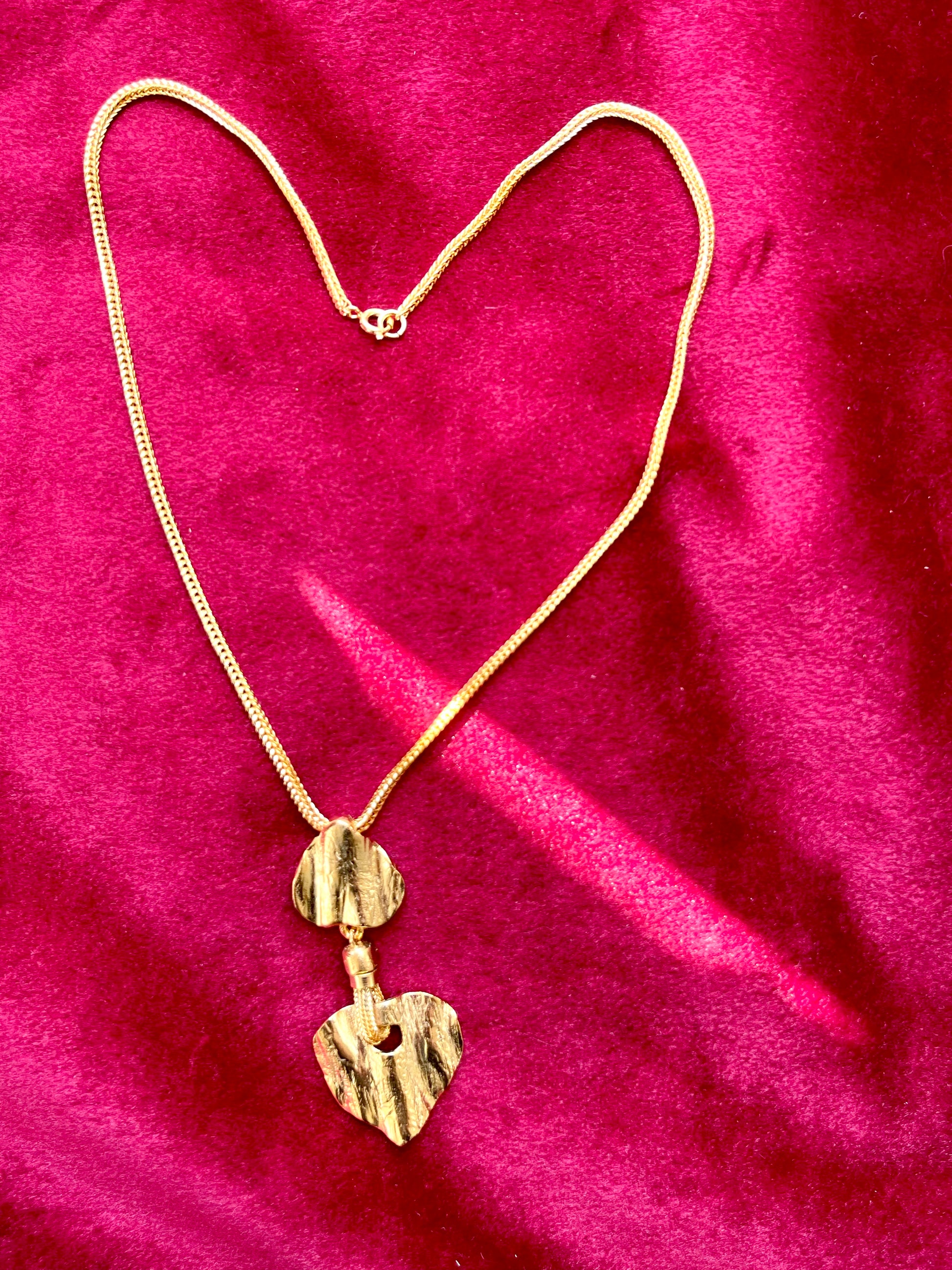 Gold-tone vintage Yves Saint Laurent necklace. The pendant features two textured, sculptural heart-shaped elements in a brushed gold finish, connected vertically for an artistic vintage look