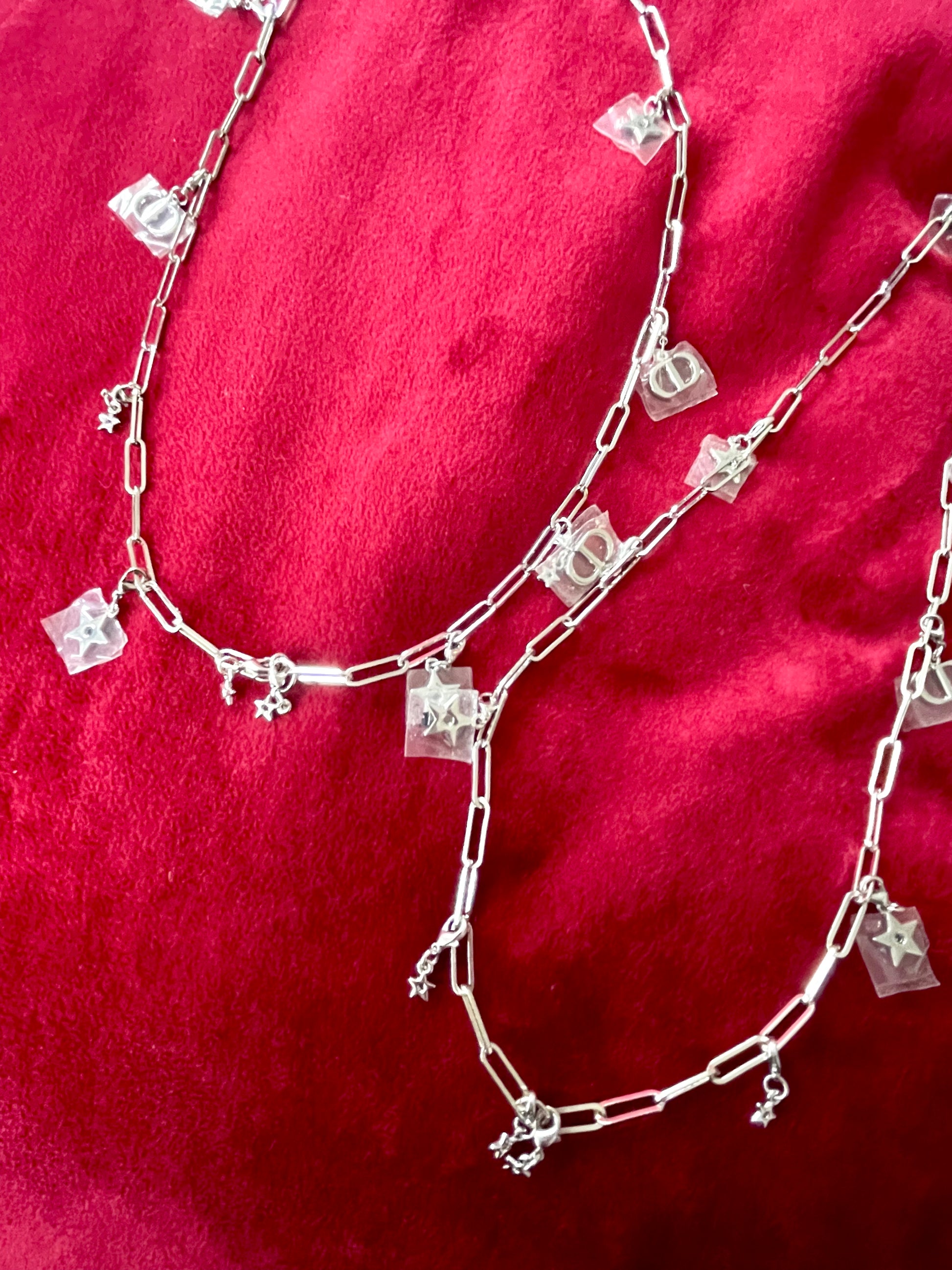Upcycled Dior Beauté phone charm necklaces with removable silver-tone charms close up 