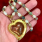 Vintage Yves Saint Laurent Flower petal pendant with a fresh water pearl and precious stones necklace displayed on hand 