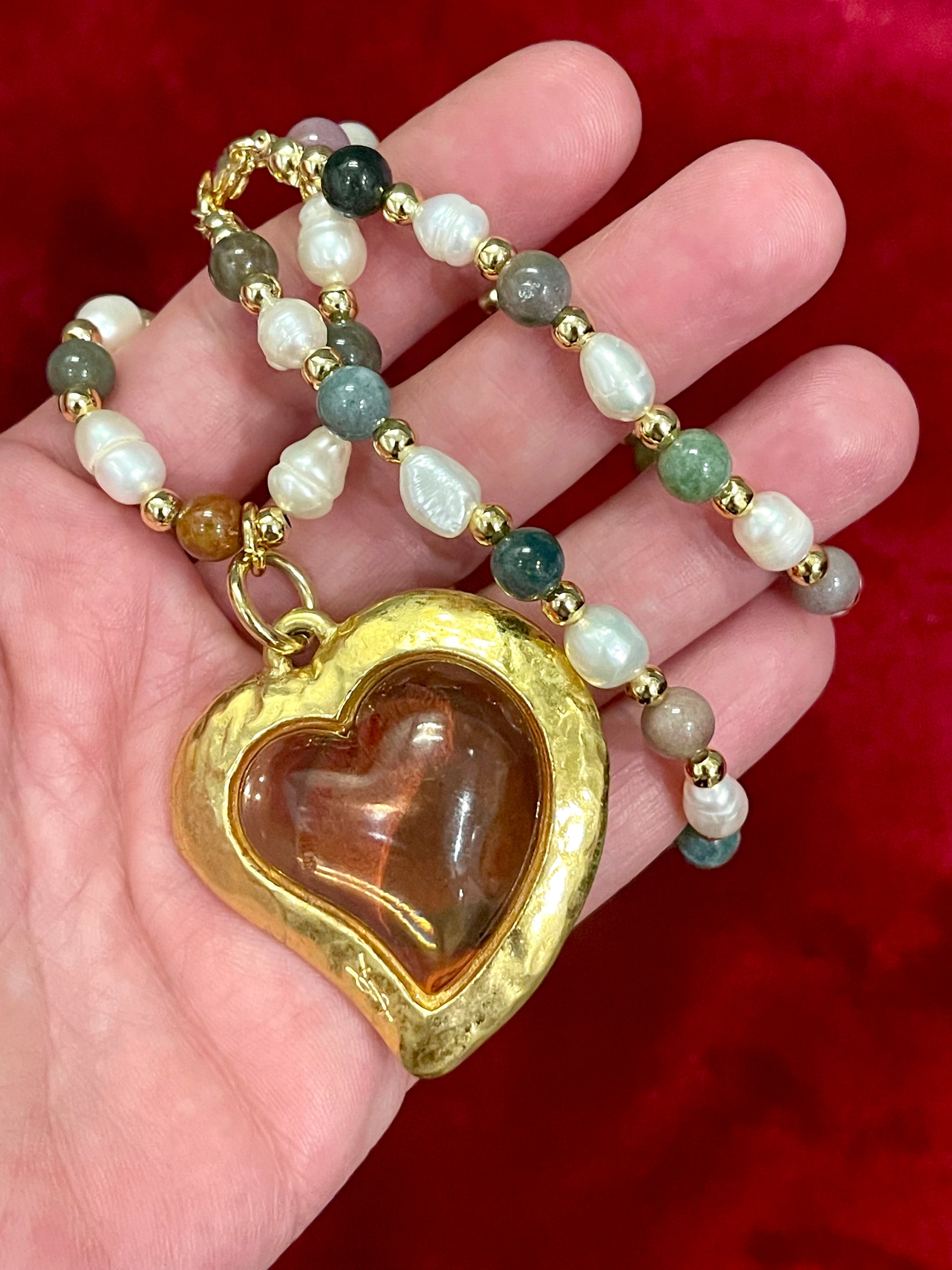 Vintage Yves Saint Laurent Flower petal pendant with a fresh water pearl and precious stones necklace displayed on hand 