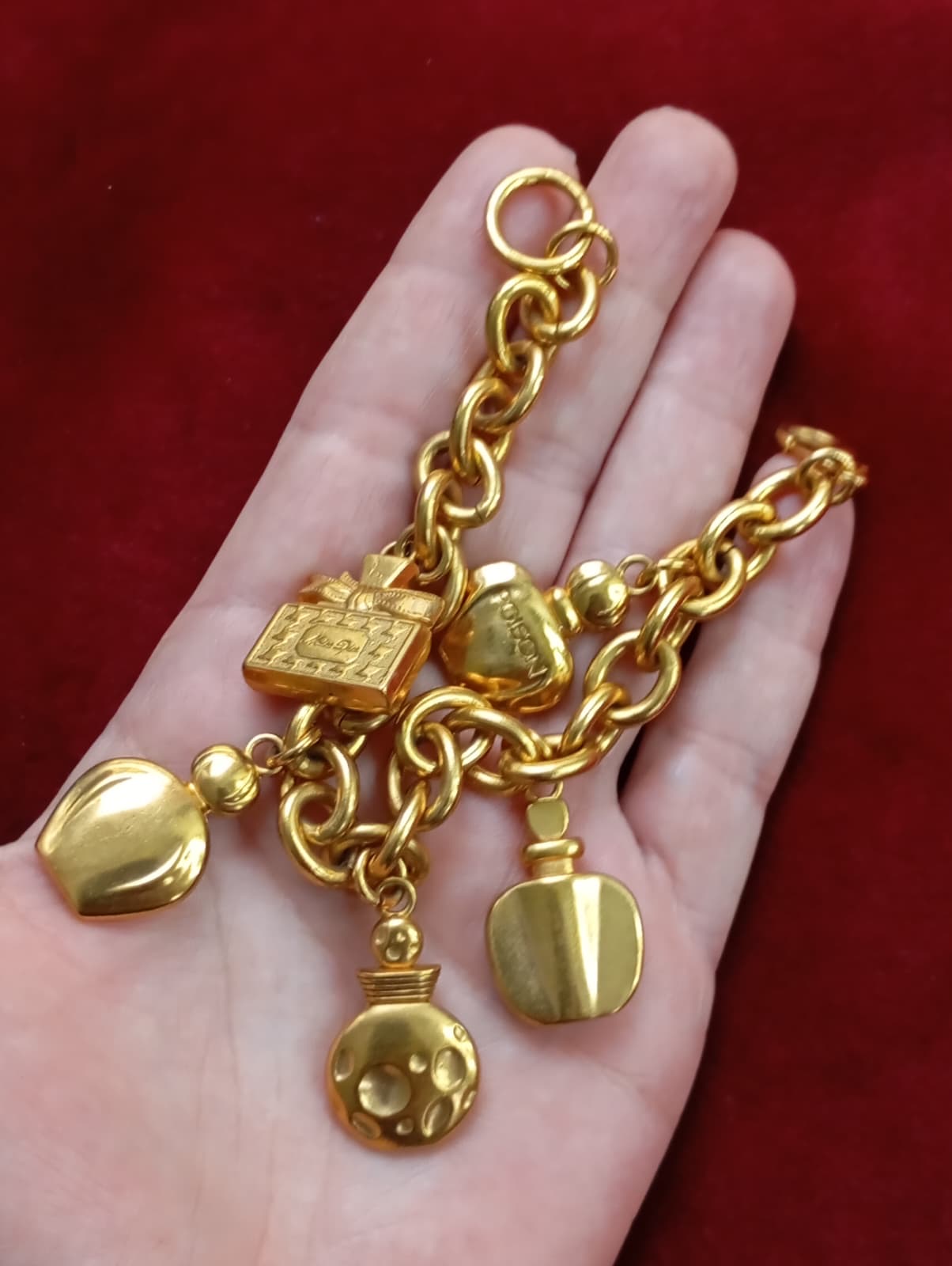 Detail of gold-tone chain and charms on Dior bracelet, very good vintage condition displayed on hand 