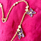 Side view of Vintage 80s five Yves Saint Laurent Butterfly Enameled pendants mounted on a Nina Ricci gold necklace, displayed on a red velvet background 