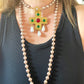 Collar largo con perlas de imitación y colgante de cruz, broche y bisutería.