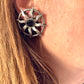 Model wearing 1980s Paco Rabanne silver-tone sun earrings with dark faceted center stones, highlighting detailing and condition.
