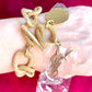 Gold-tone vintage Yves Saint Laurent chain bracelet worn on wrist with YSL logo charm and medallion on red background 