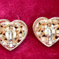 Back view showing signature of a Pair of 3 cm gold-tone vintage Yves Saint Laurent heart-shaped clip-on earrings decorated with multi-coloured crystals, displayed on a red background