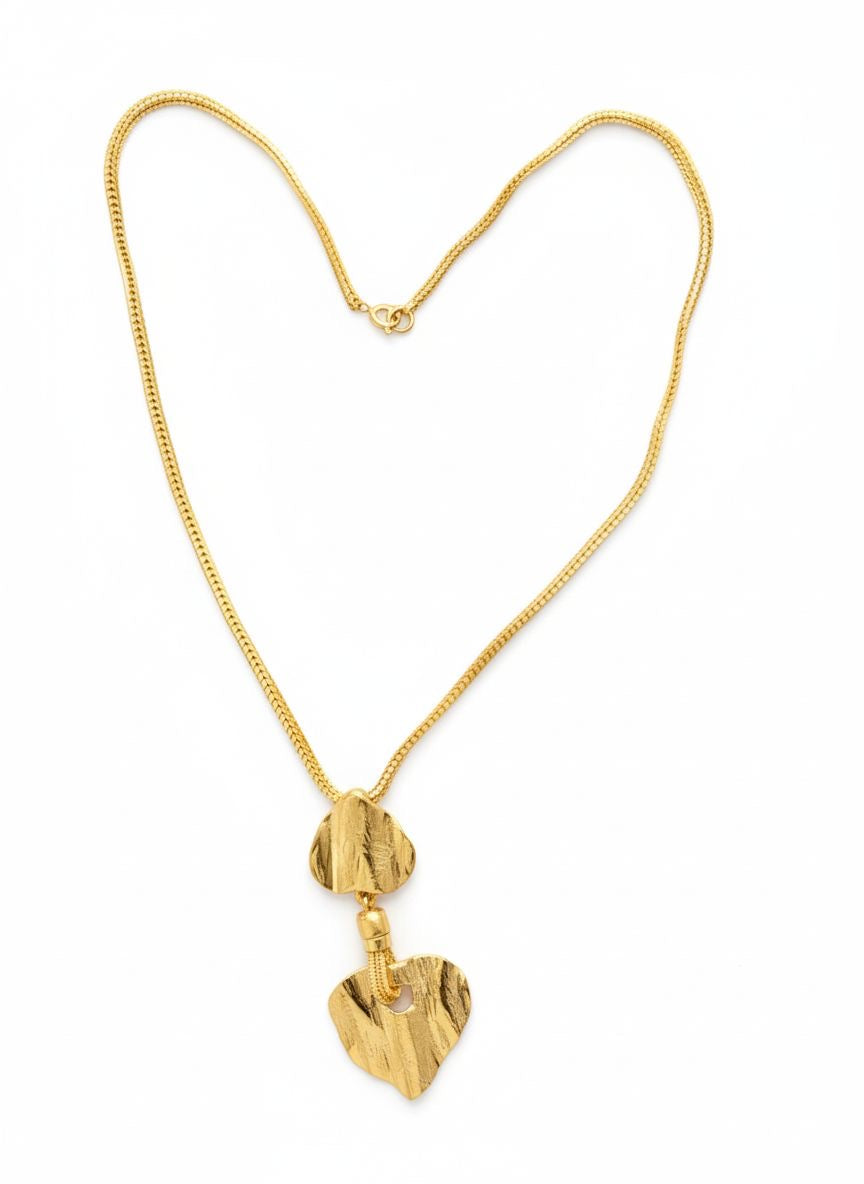 Vintage Yves Saint Laurent Arty Gold-tone necklace forming a heart shape with its chain. The pendant features two textured, sculptural heart-shaped elements in a brushed gold finish, connected vertically for an artistic vintage look