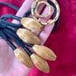 Close-up of vintage Yves Saint Laurent YSL gold tone scarf holder signed Made in France showing details of pendants