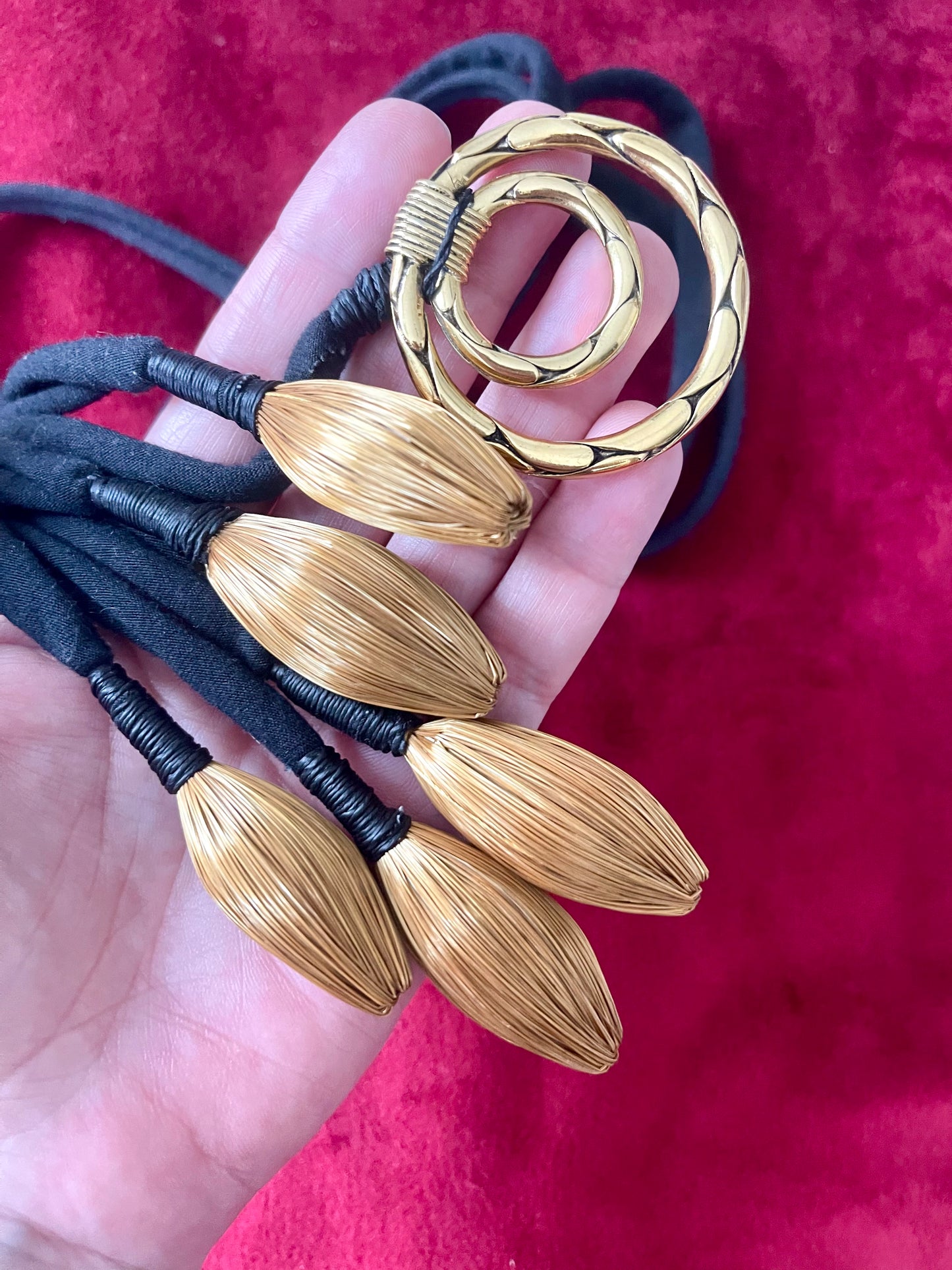 Close-up of vintage Yves Saint Laurent YSL gold tone scarf holder signed Made in France showing details of pendants