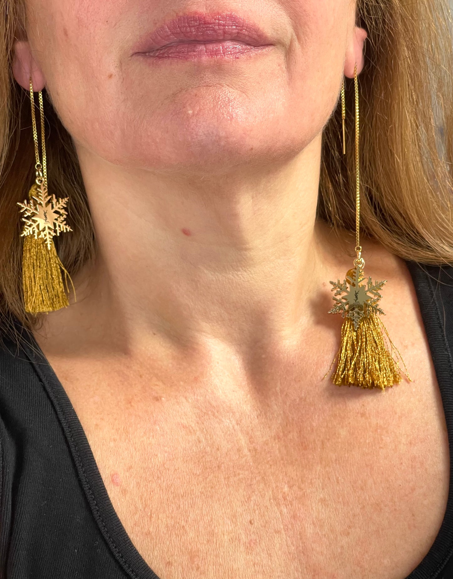 Worn by model Yves Saint Laurent snowflake charm tassel earrings in gold tone, asymmetrical showing the size difference 