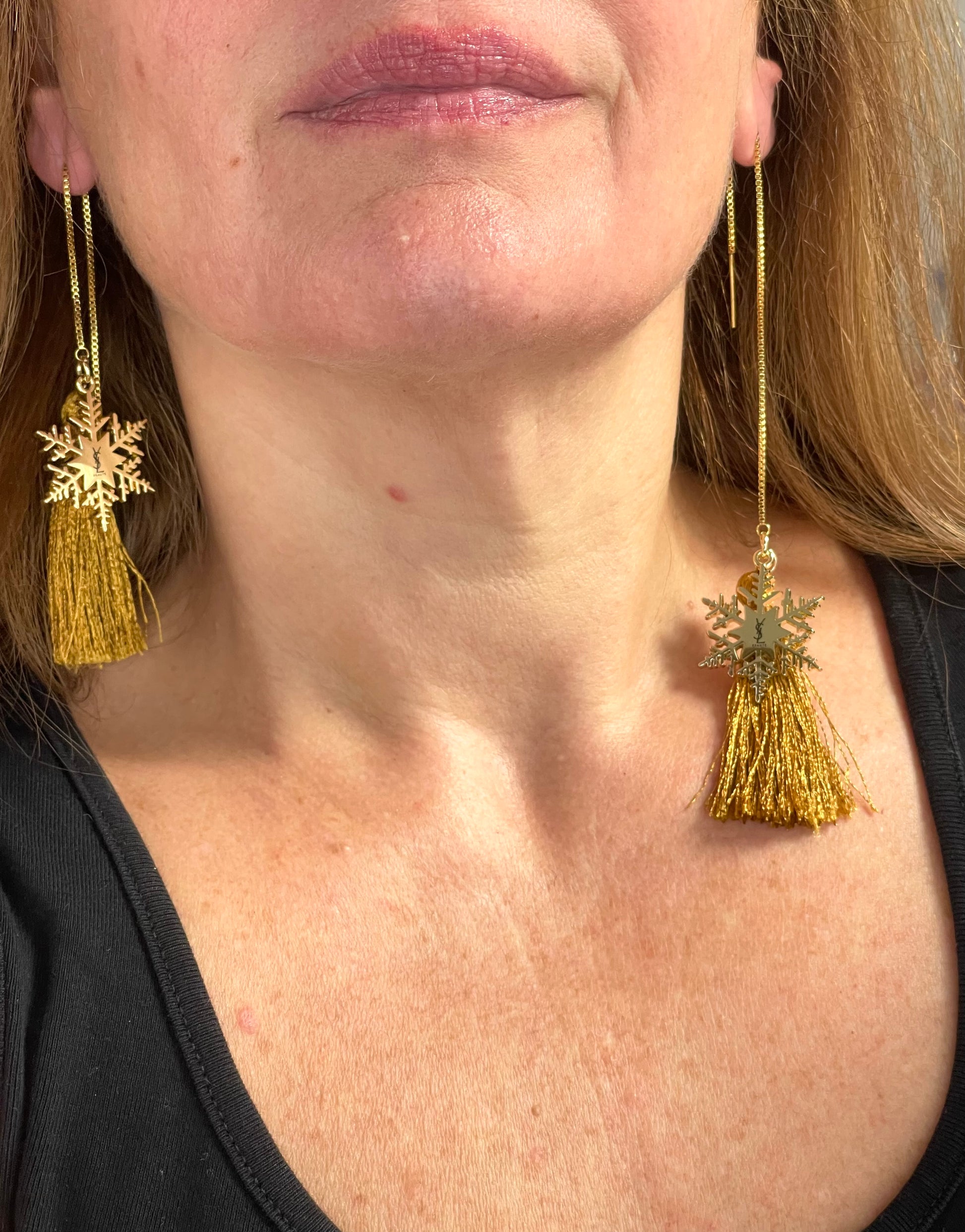 Worn by model Yves Saint Laurent snowflake charm tassel earrings in gold tone, asymmetrical showing the size difference 