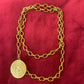Yves Saint Laurent vintage scarf holder Gold chain necklace on a red fabric 