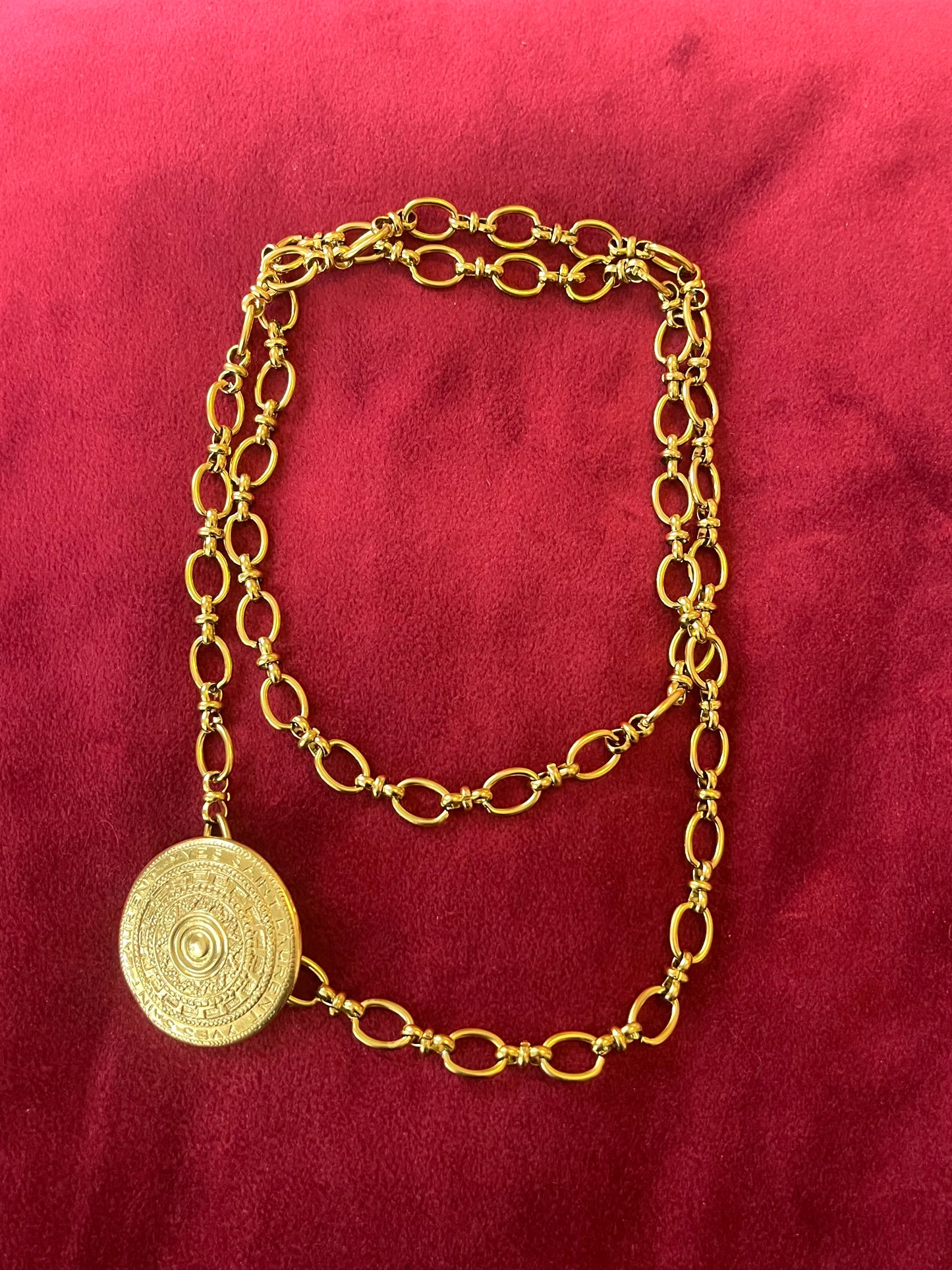 Yves Saint Laurent vintage scarf holder Gold chain necklace on a red fabric 