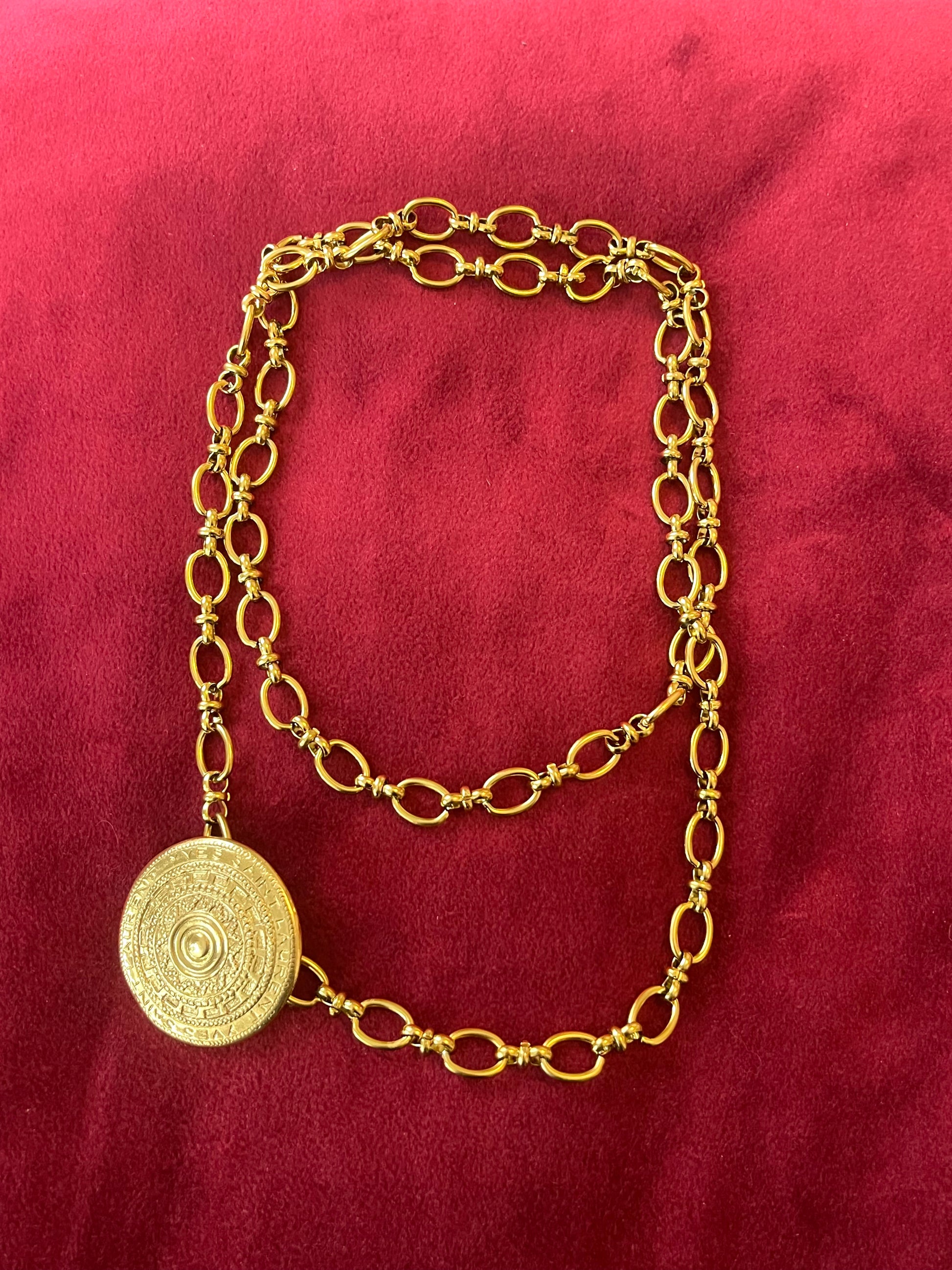 Yves Saint Laurent vintage scarf holder Gold chain necklace on a red fabric 