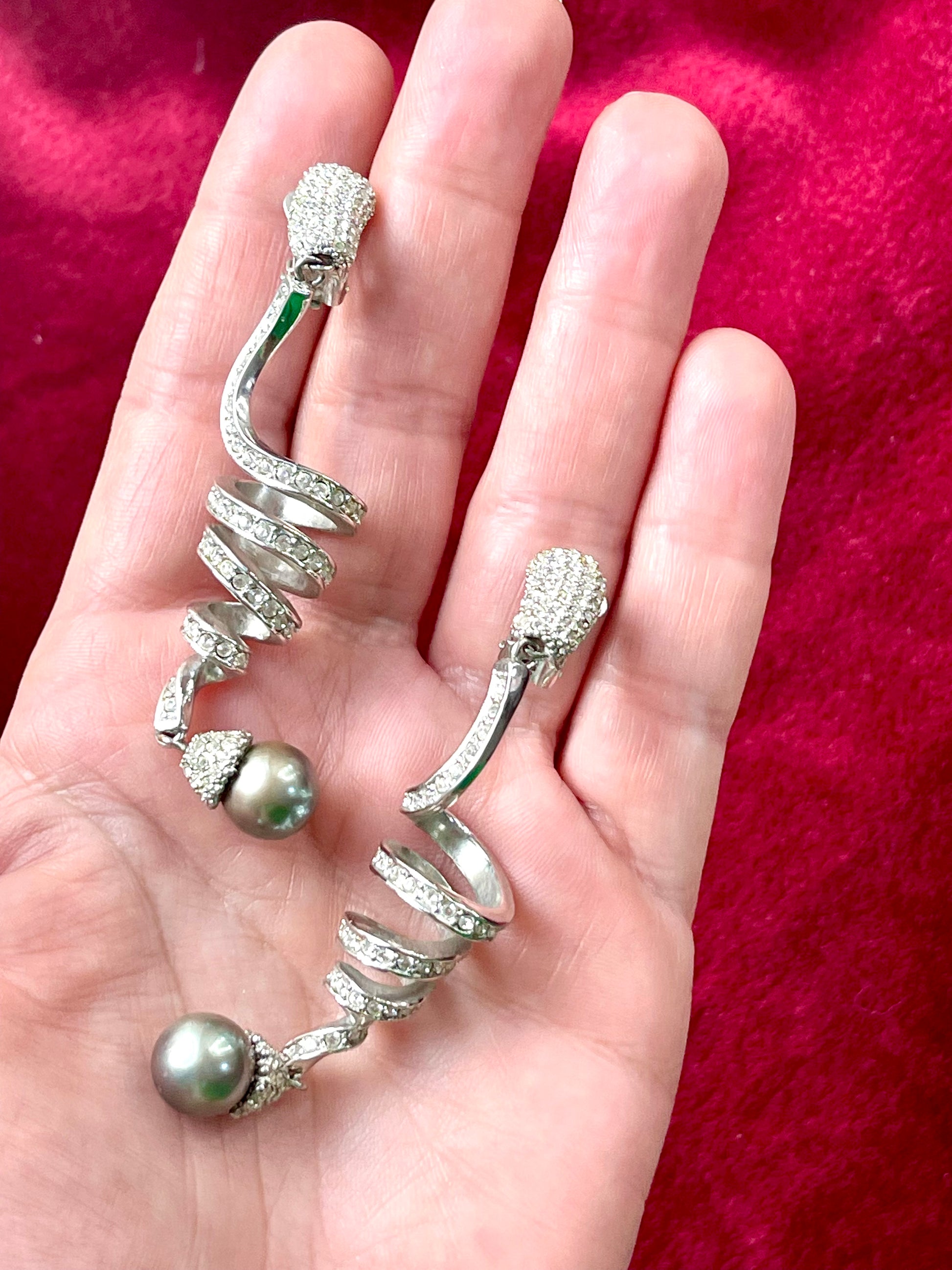 Side by side on hand showing Grossé earrings Dior elegant drop design and pearl detail