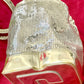 Side view of Paco Rabanne silver shoulder/wrist bag with both straps shown, on red velvet fabric background.