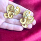 Displayed on hand Back view of signed Nina Ricci Paris earrings in matte gold plated metal, minor signs of wear visible