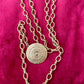 Top view Yves Saint Laurent vintage scarf holder Gold chain necklace on red fabric 