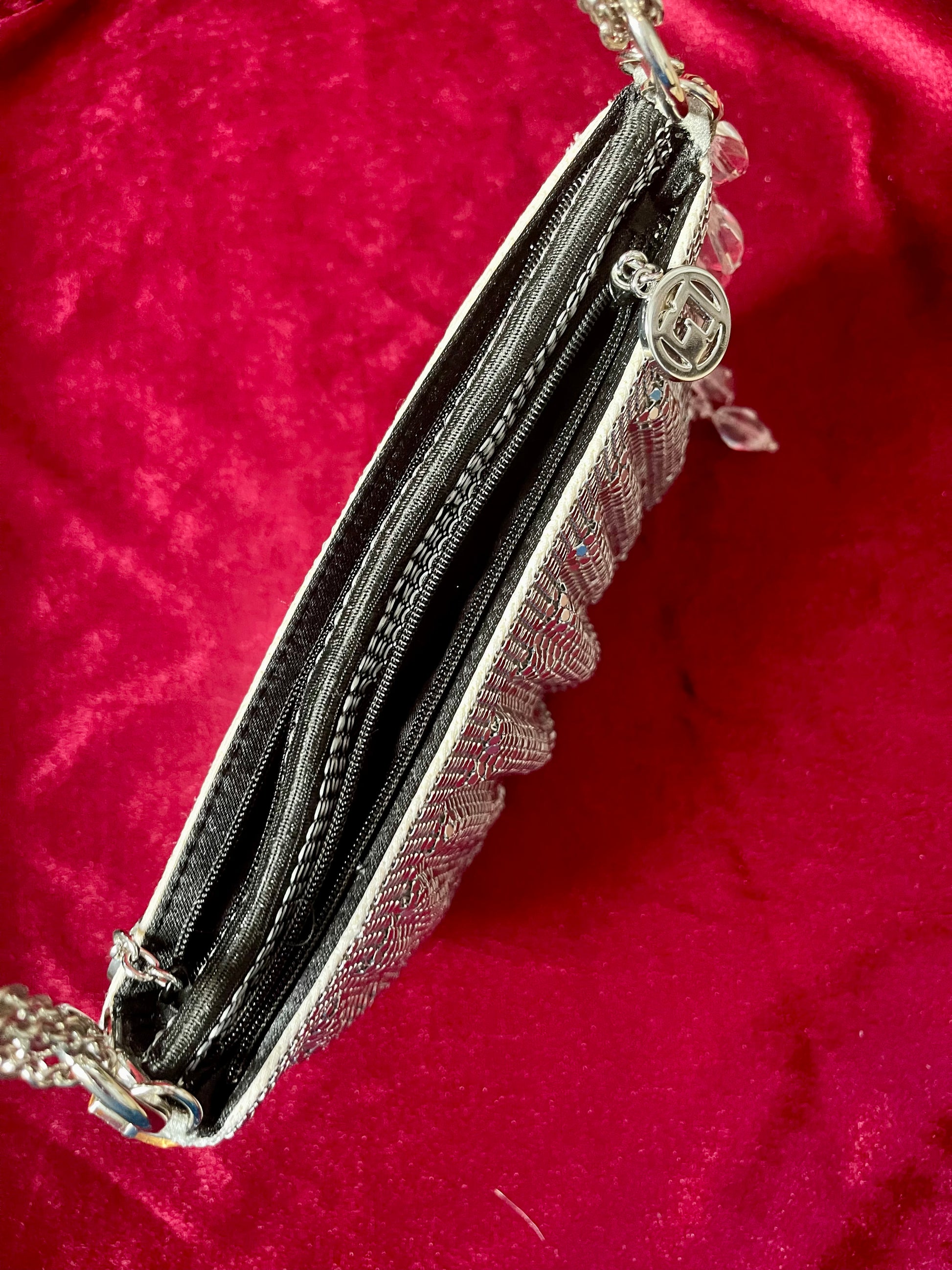 Top view on the One of a kind handmade Paco Rabanne repurposed silver pixel mesh bag showing the two compartments on a red background 