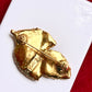 Back view Vintage Yves Saint Laurent 80s 90s gold tone leaf brooch excellent condition on white and red background 
