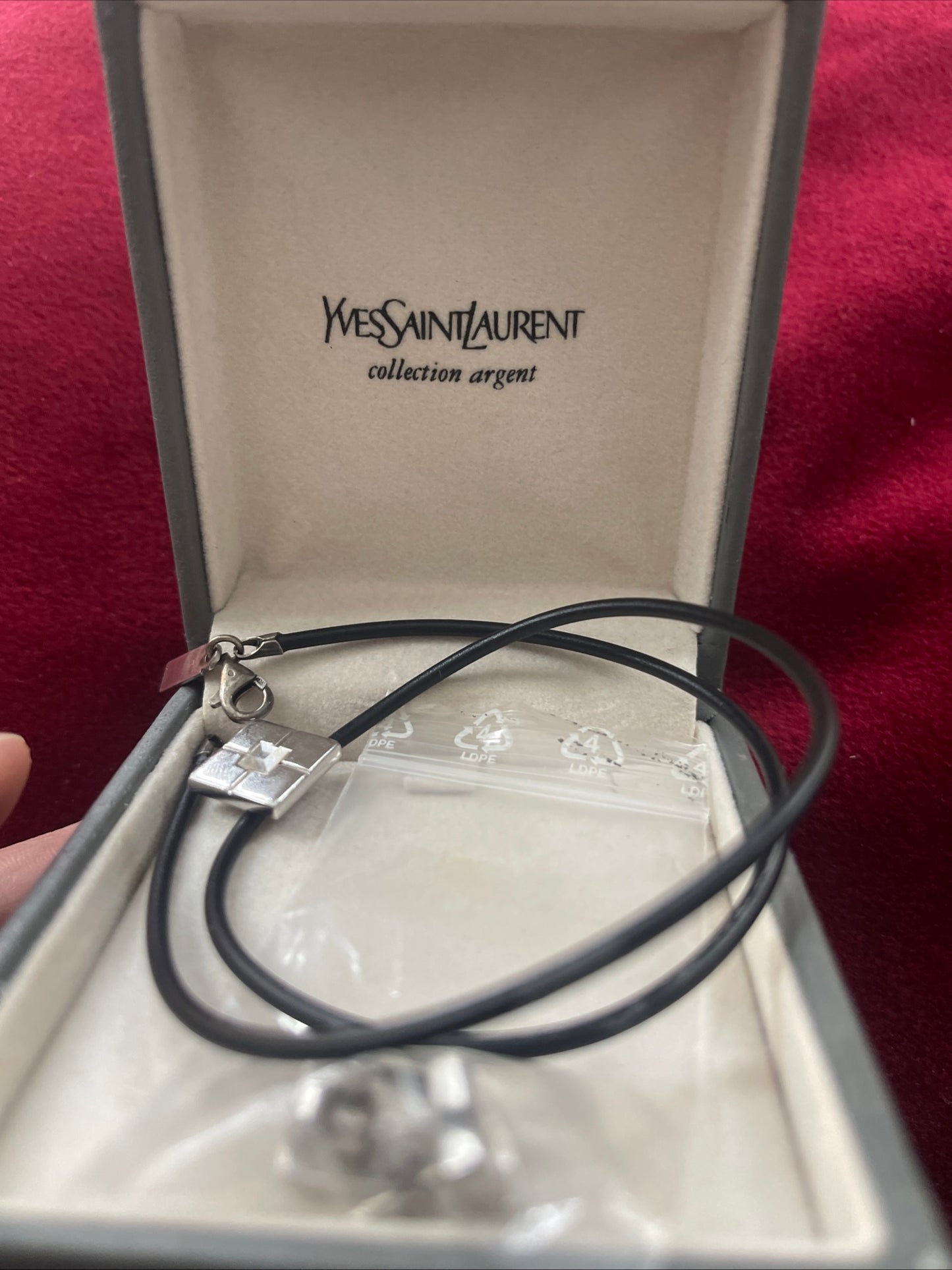 YSL vintage silver earrings and matching pendant necklace set placed together on Their original box