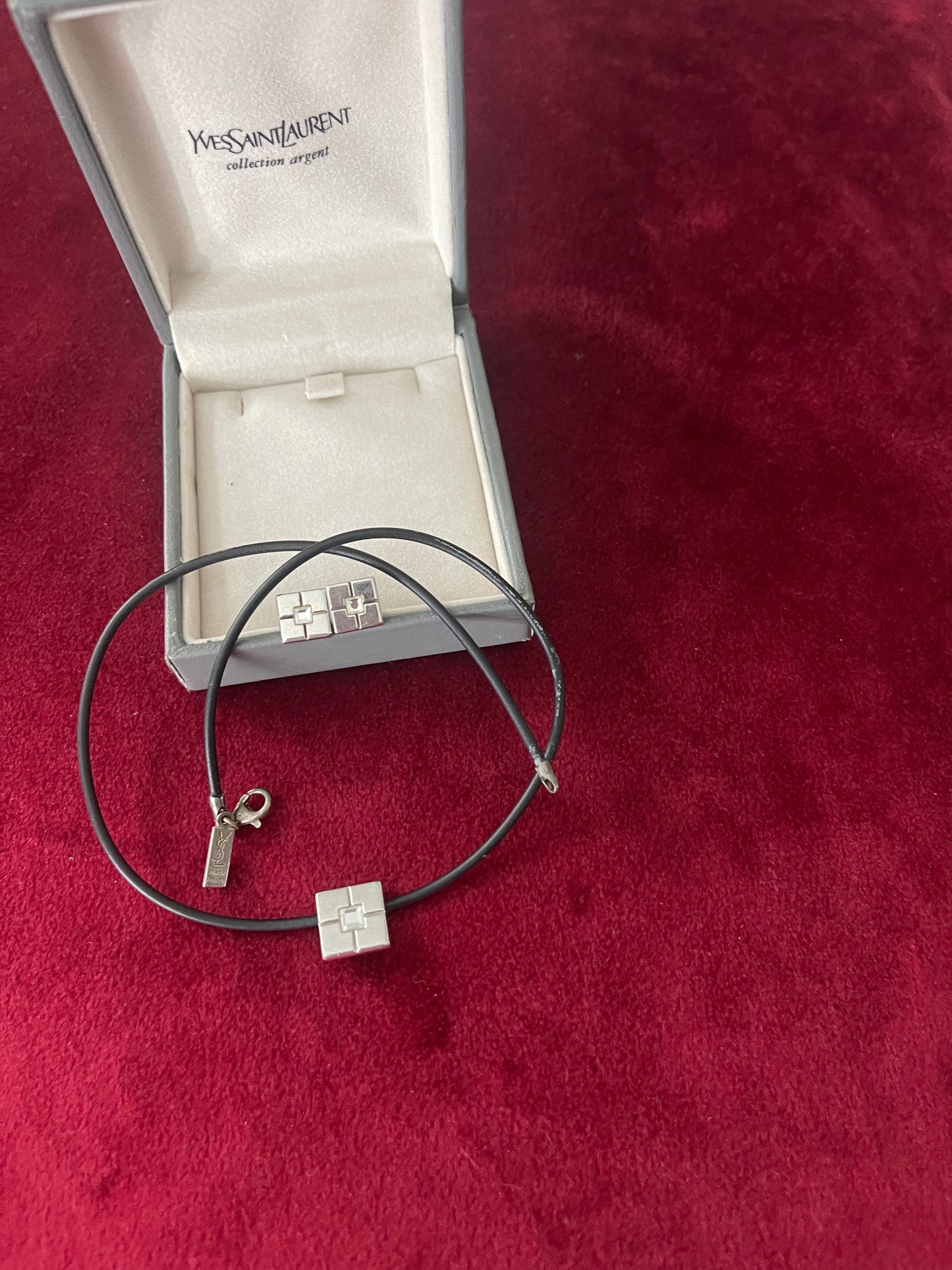Vintage Yves Saint Laurent silver 925 earrings and pendant necklace set displayed on a red velvet background With their collection silver box
