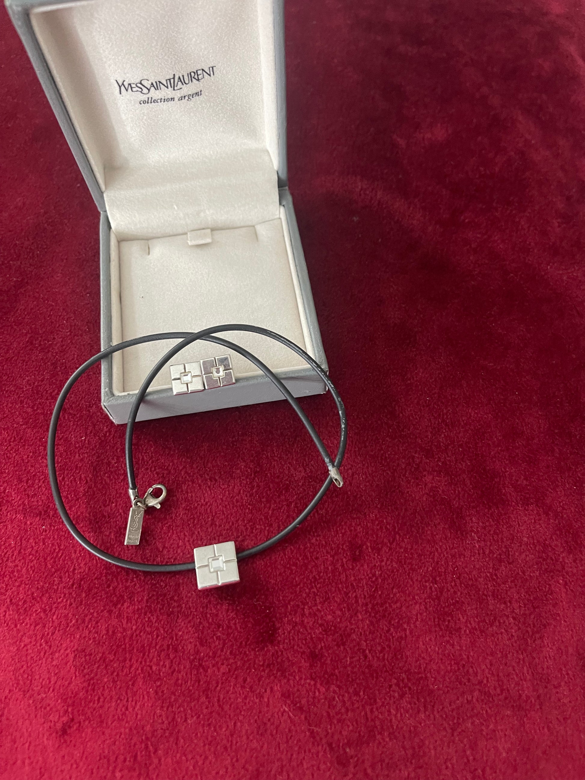 Vintage Yves Saint Laurent silver 925 earrings and pendant necklace set displayed on a red velvet background With their collection silver box