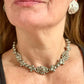 Side view of a model wearing a vintage Yves Saint Laurent silver necklace with hexagonal YSL Monogram earrings.