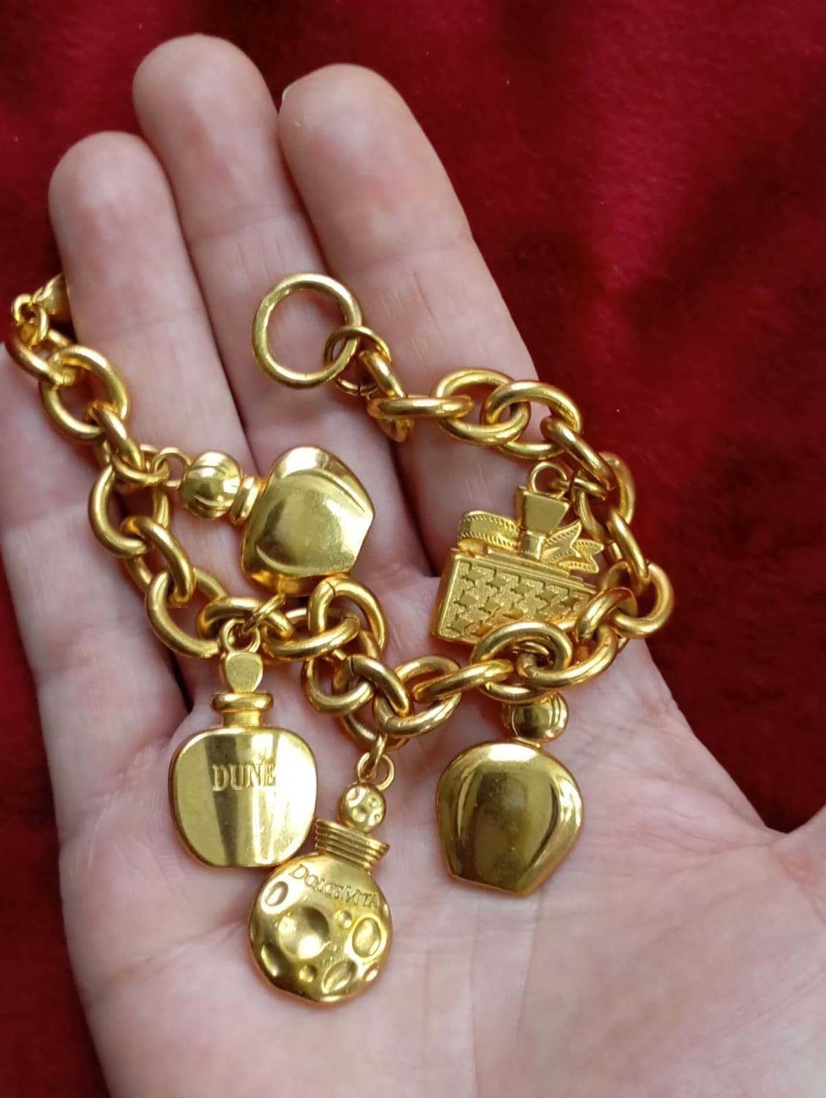 Close up view Detail of gold-tone chain and charms on Dior bracelet, very good vintage condition displayed on hand 