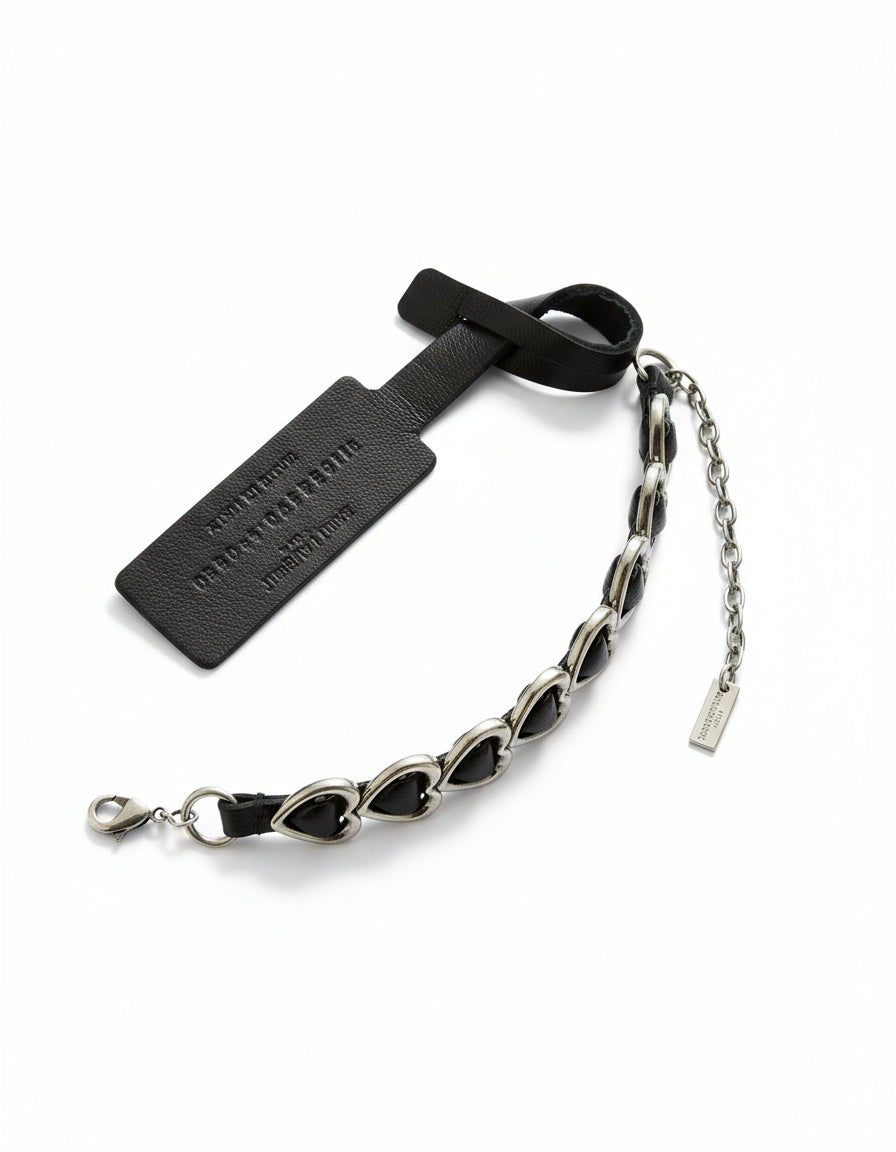 A vintage Yves Saint Laurent heart design black leather and dark steel metal bracelet, 
