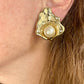 Close up on model wearing Vintage YSL statement earrings featuring gold-tone floral calla lily shape and luminous pearls