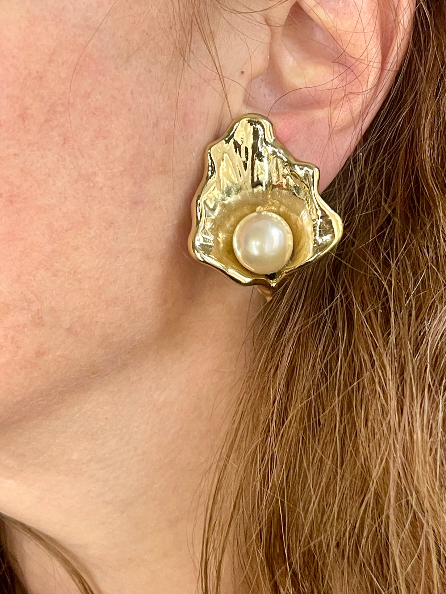 Close up on model wearing Vintage YSL statement earrings featuring gold-tone floral calla lily shape and luminous pearls