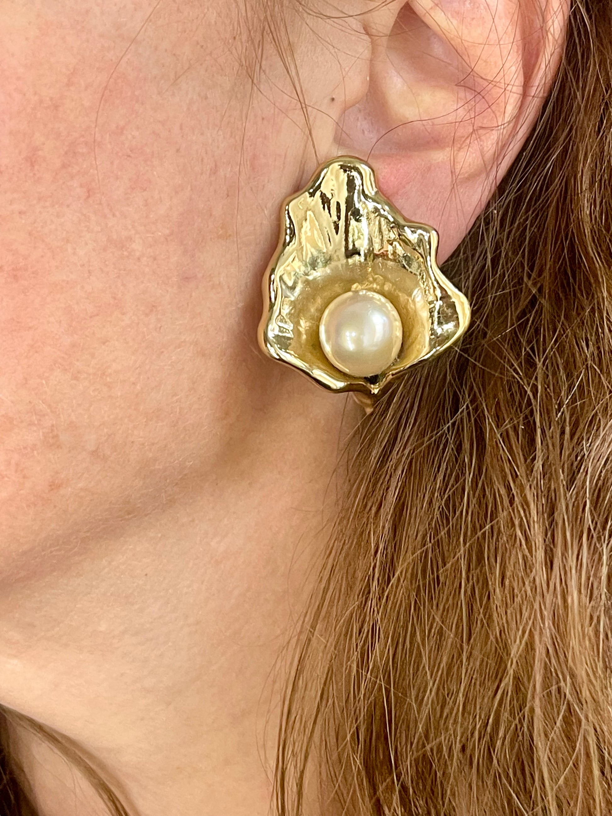 Close up on model wearing Vintage YSL statement earrings featuring gold-tone floral calla lily shape and luminous pearls