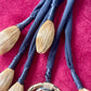 Close up of Art textile necklace with black fabric cords and gold tone pompom elements