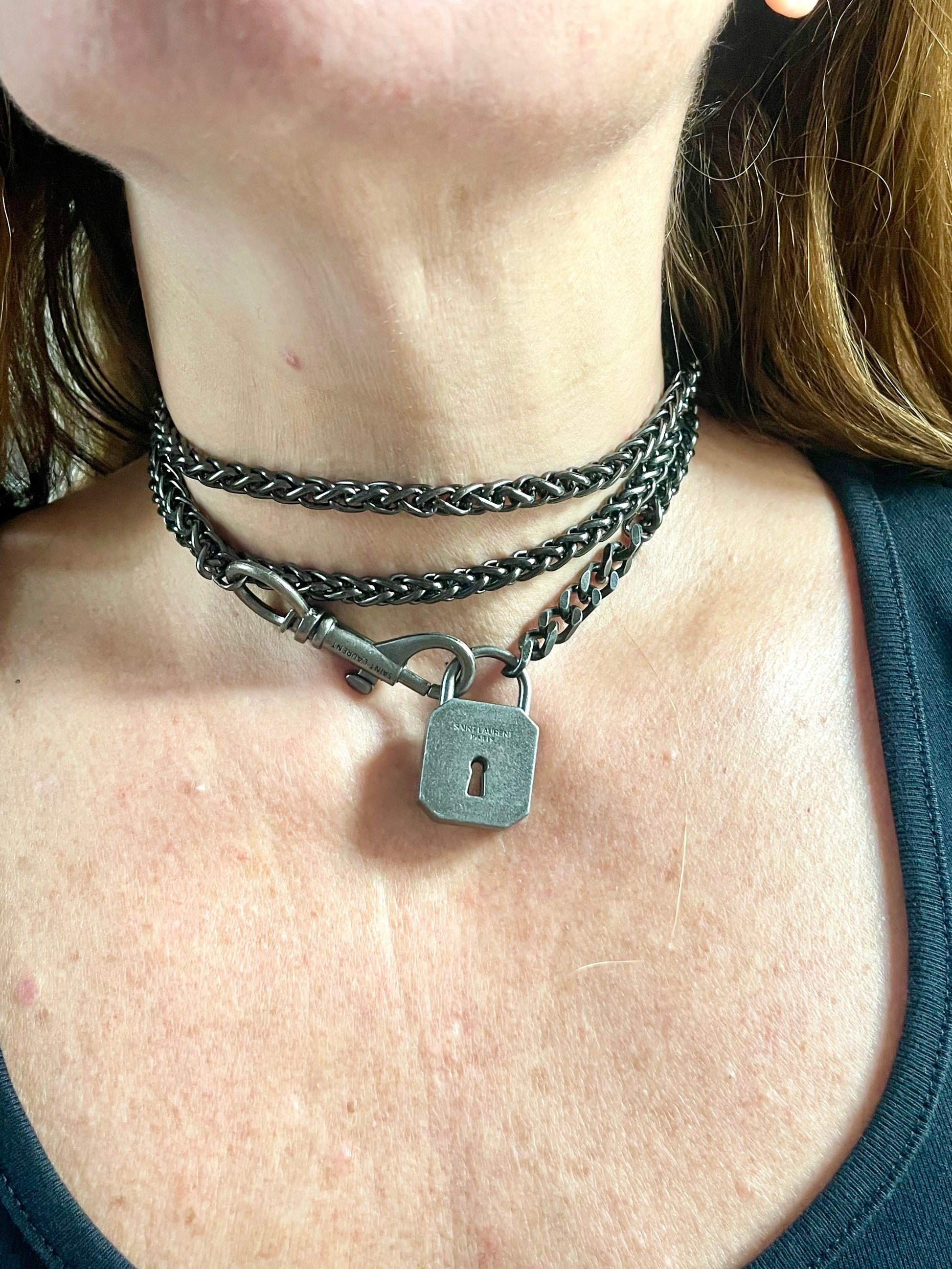 Worn by model close up on Vintage Saint Laurent upcycled necklace featuring a dark gunmetal chain with original lock and key charm pendant, repurposed from a Saint Laurent keychain
