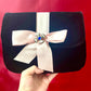 Clutch vintage modificado con broche de Yves Saint Laurent