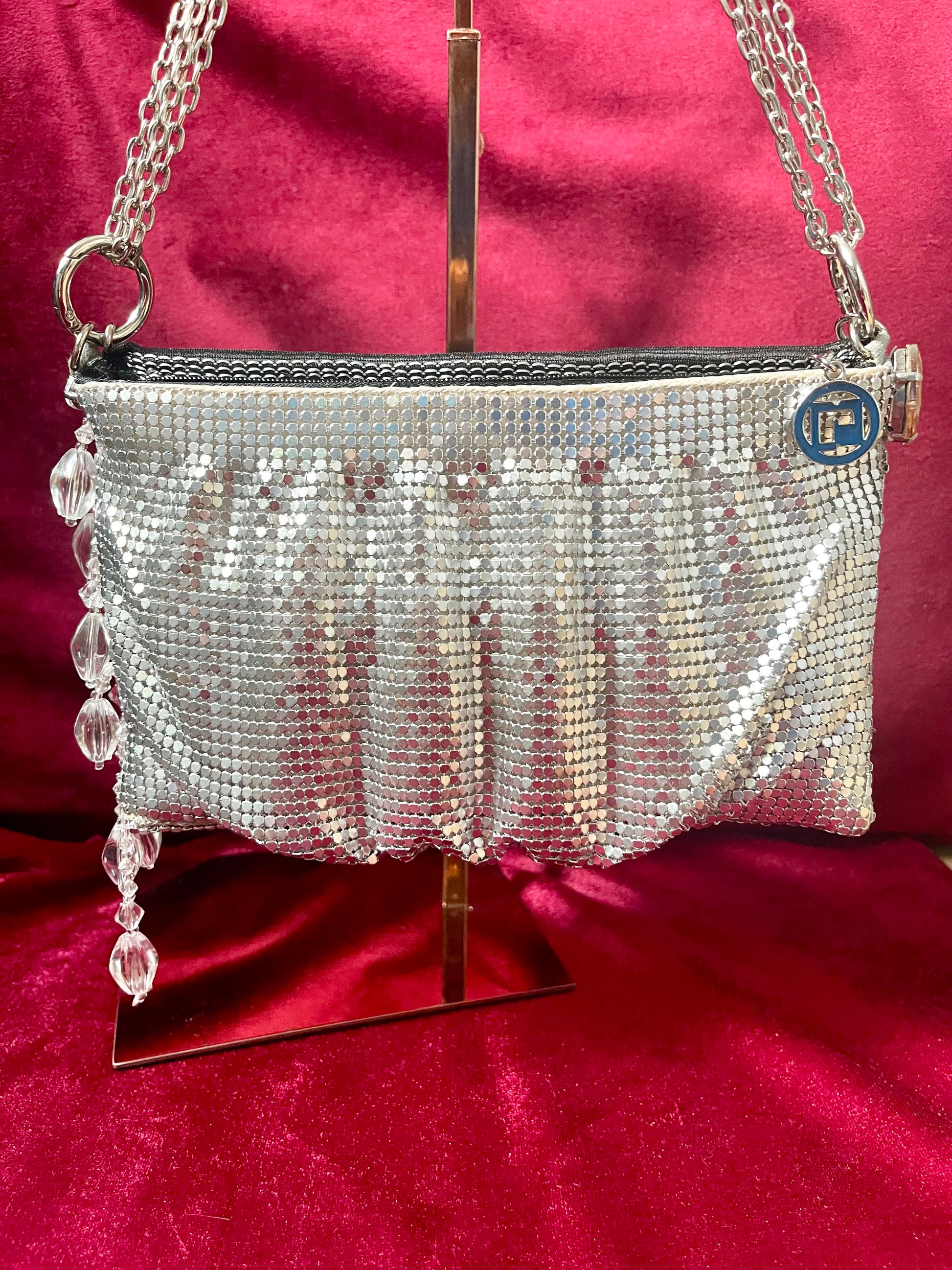 Front view of the One of a kind handmade Paco Rabanne repurposed silver pixel mesh bag on a red background 