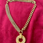 Gold tone Yves Saint Laurent vintage pendant  stainless steel chain necklace on red background 