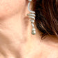 Close up left side Dior Grossé earrings worn, showcasing elegant drop design and pearl detail