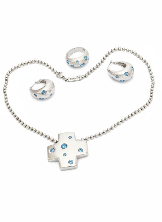 Vintage YSL silver jewelry set displayed on red fabric: silver earrings, cross pendant necklace on beaded chain and ring 