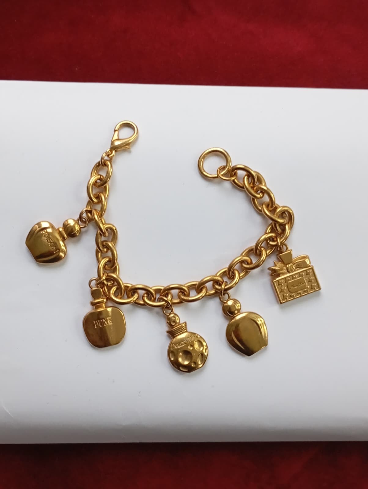 Vintage Dior bracelet on red and white background showing all charms