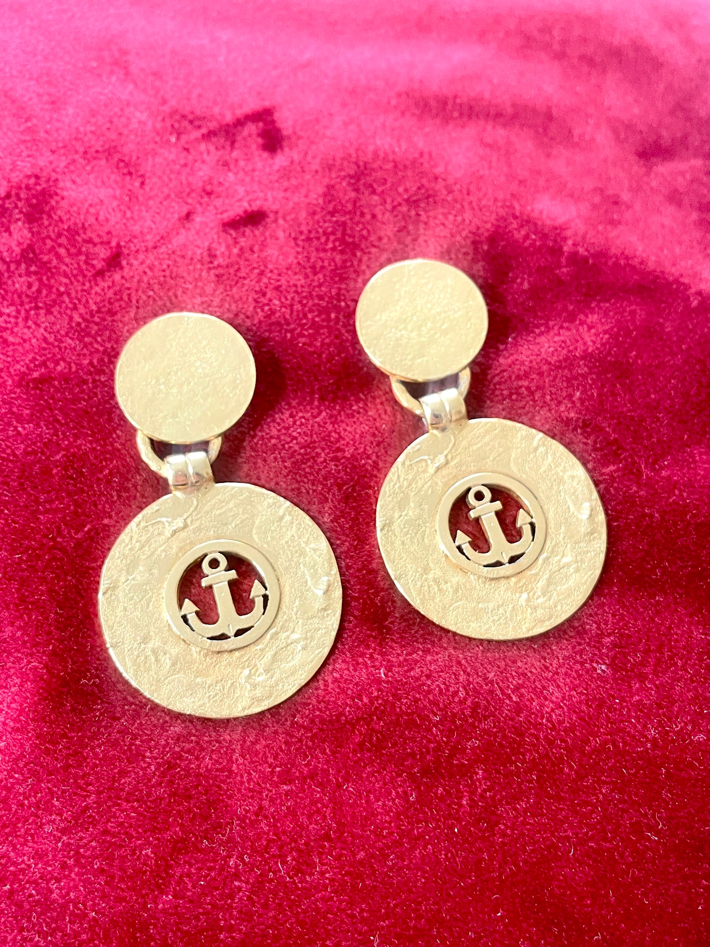 Vintage 1980s Yves Saint Laurent gold-tone anchor earrings with textured circular drop, clip-on design.