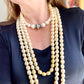 Vintage Yves Saint Laurent multi-strand pearl necklace layered with shorter pearls for a sophisticated, fashion-forward look.