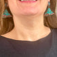 Close-up of Yves Saint Laurent Rive Gauche vintage statement earrings with turquoise and red rhinestones worn by model showing the pair