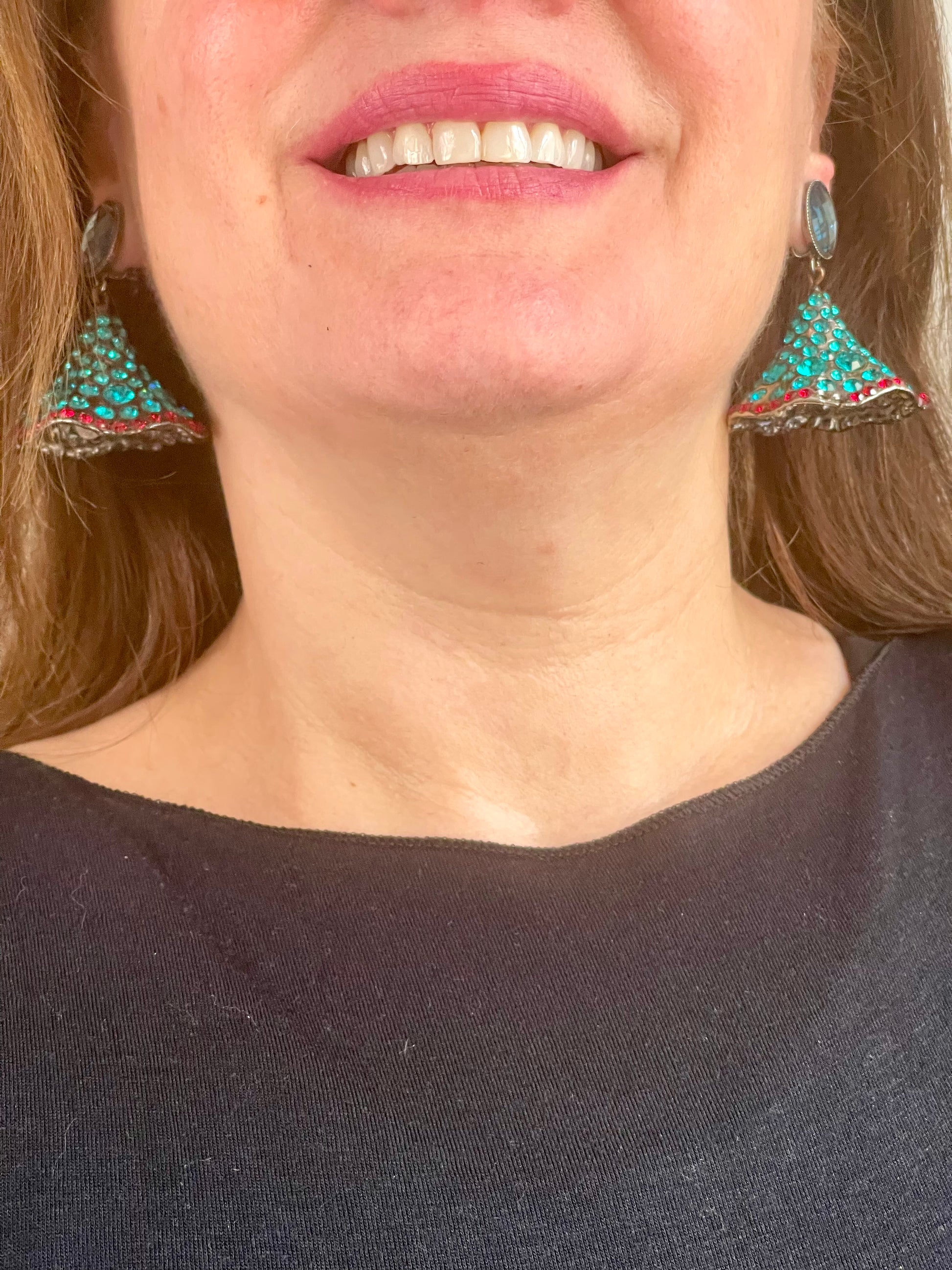 Close-up of Yves Saint Laurent Rive Gauche vintage statement earrings with turquoise and red rhinestones worn by model showing the pair