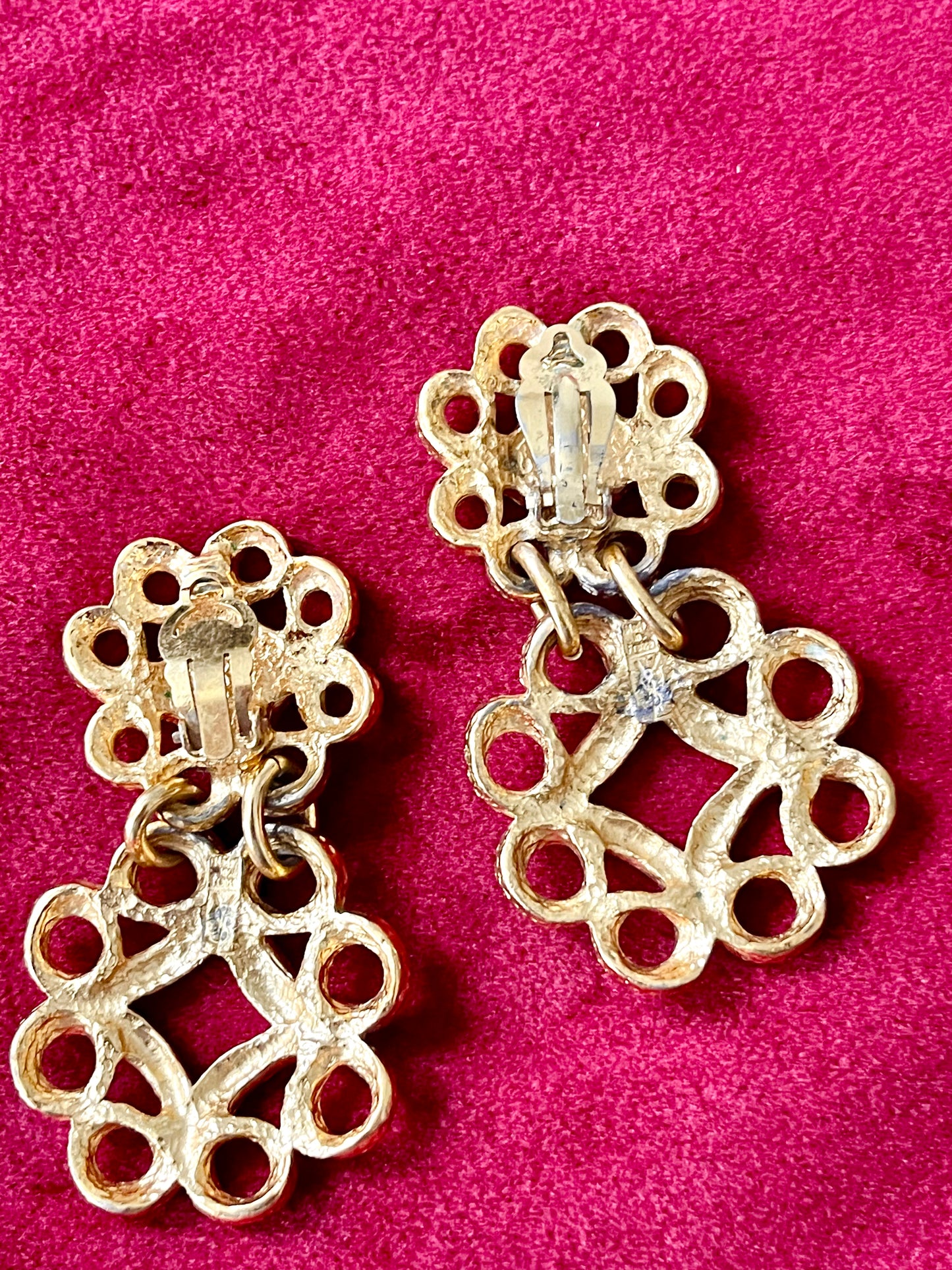 Back view of vintage YSL gold-tone earrings showing textured metal, clip-on closure, and the YSL signature mark on the lower segment