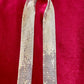 Flat lay of vintage silver Paco Rabanne mesh belt on red velvet background.