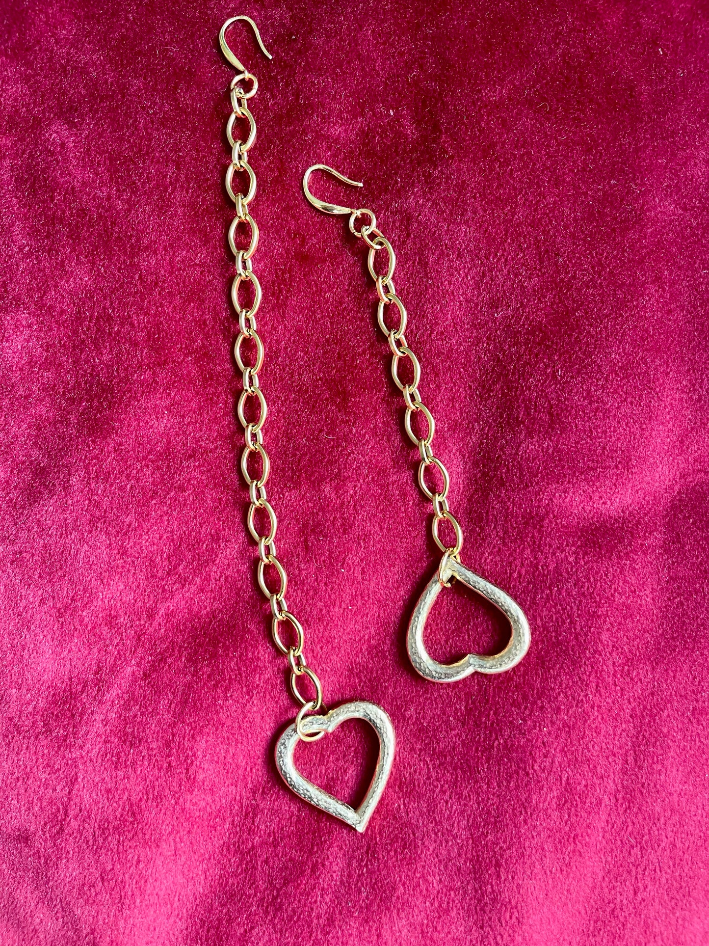 Asymmetrical Yves Saint Laurent earrings laid flat, back view