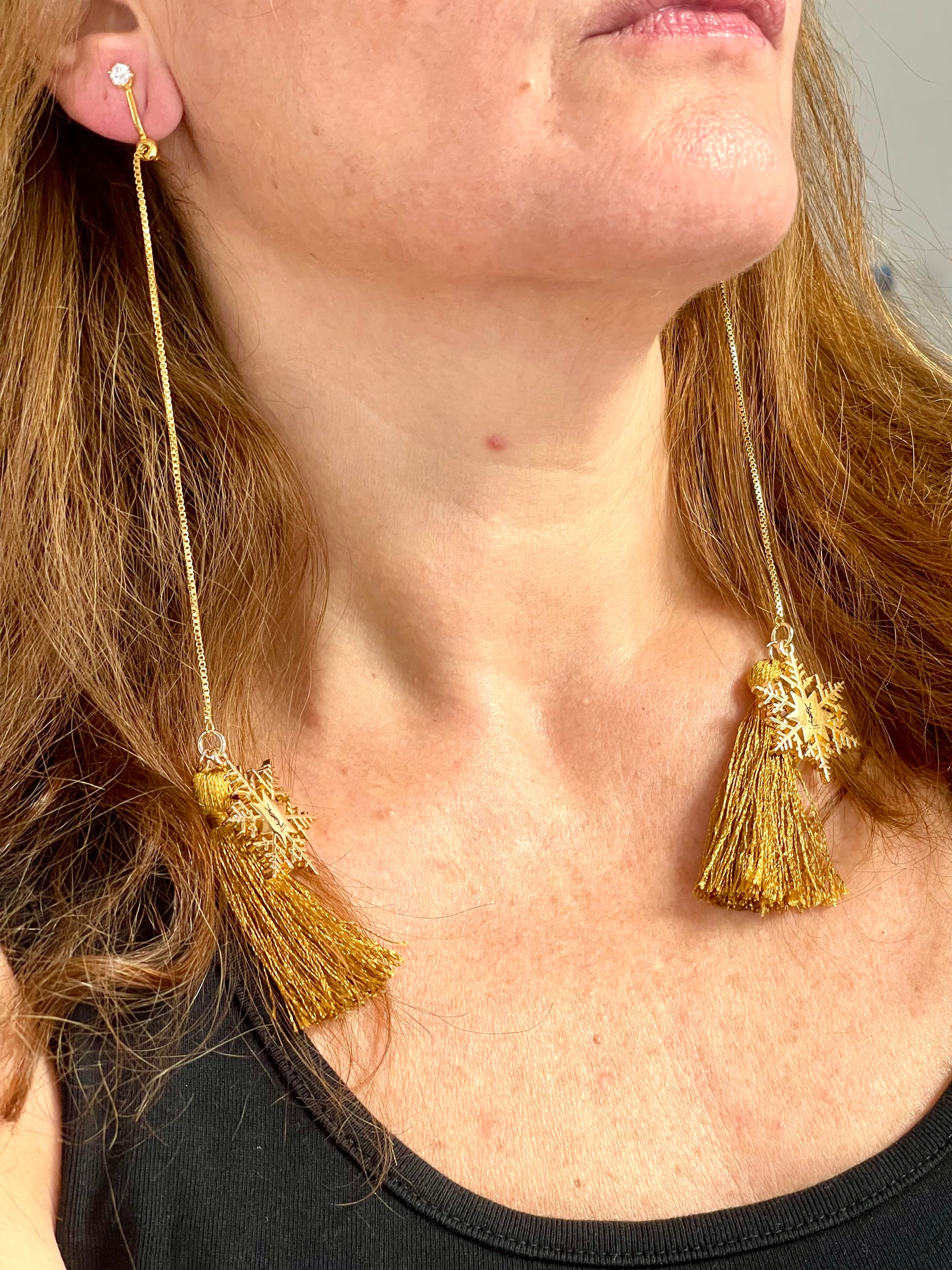 Worn by model using the clip-ons Yves Saint Laurent signed snowflake charm tassel earrings