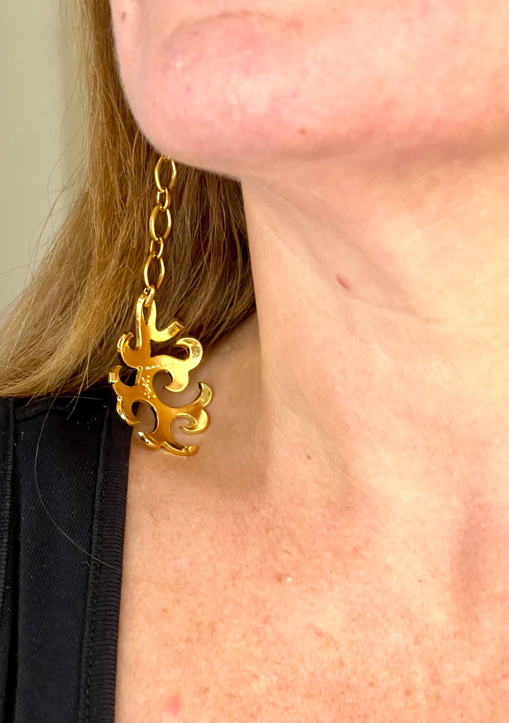 Backside of Yves Saint Laurent long drop earrings worn by model photographed from different angle